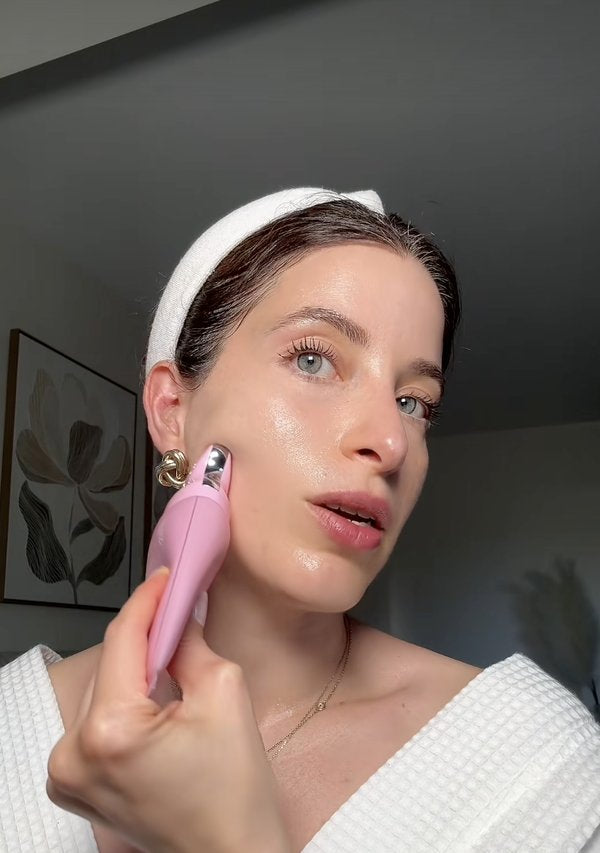 Woman gliding the gua sha tip along her jaw toward her ear